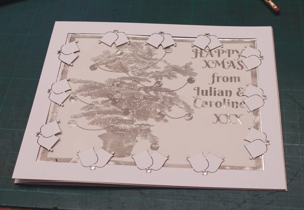 Christmas card cut with laser, backed with foil.